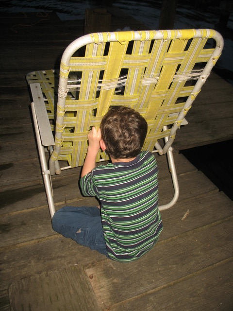 Connor taking shelter behind a lawn chair to hide from the ignition