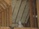 Closer view of one ceiling/wall area and one of the guys spraying it