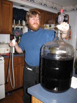 February 10: Don getting ready to siphon the blueberry mead he brewed late last June into bottles