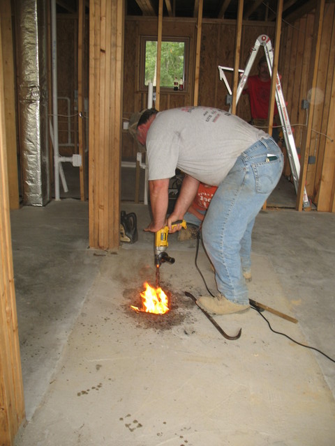 July 3: Another trip to see house progress. Jimmy attempting to drill and burn the wood out of the masonry heater flue